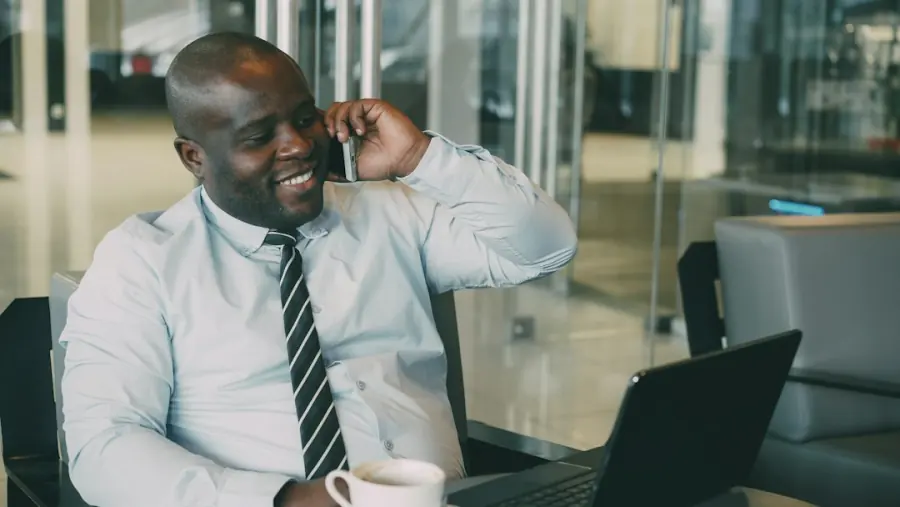Smiling business traveller on a phone call with a laptop, corporate travel in Uganda