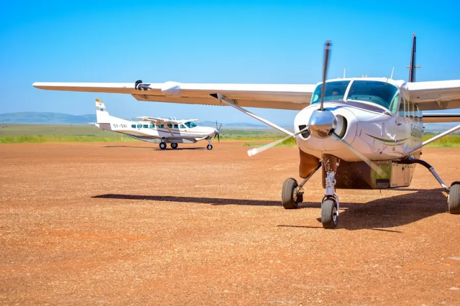 Cessna Caravan light aircraft parked on a dirt airstrip, domestic flights in Uganda