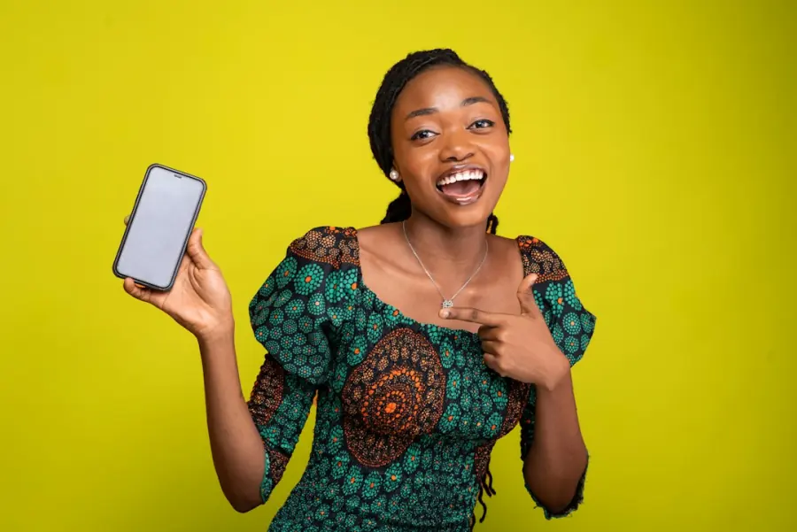 Smiling woman holding a phone, contact Speedwing on WhatsApp